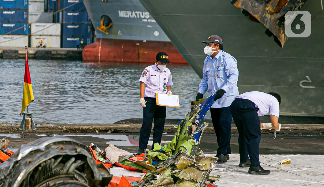 Petugas Komite Nasional Keselamatan Transportasi (KNKT) melakukan identifikasi pesawat Sriwijaya Air SJ 182 di Dermaga JICT, Tanjung Priok, Jakarta, Kamis (21/1/2021). Operasi SAR korban Sriwijaya Air SJ 182 ditutup setelah berjalan selama 13 hari sejak 9 Januari 2021. (Liputan6.com/Faizal Fanani)