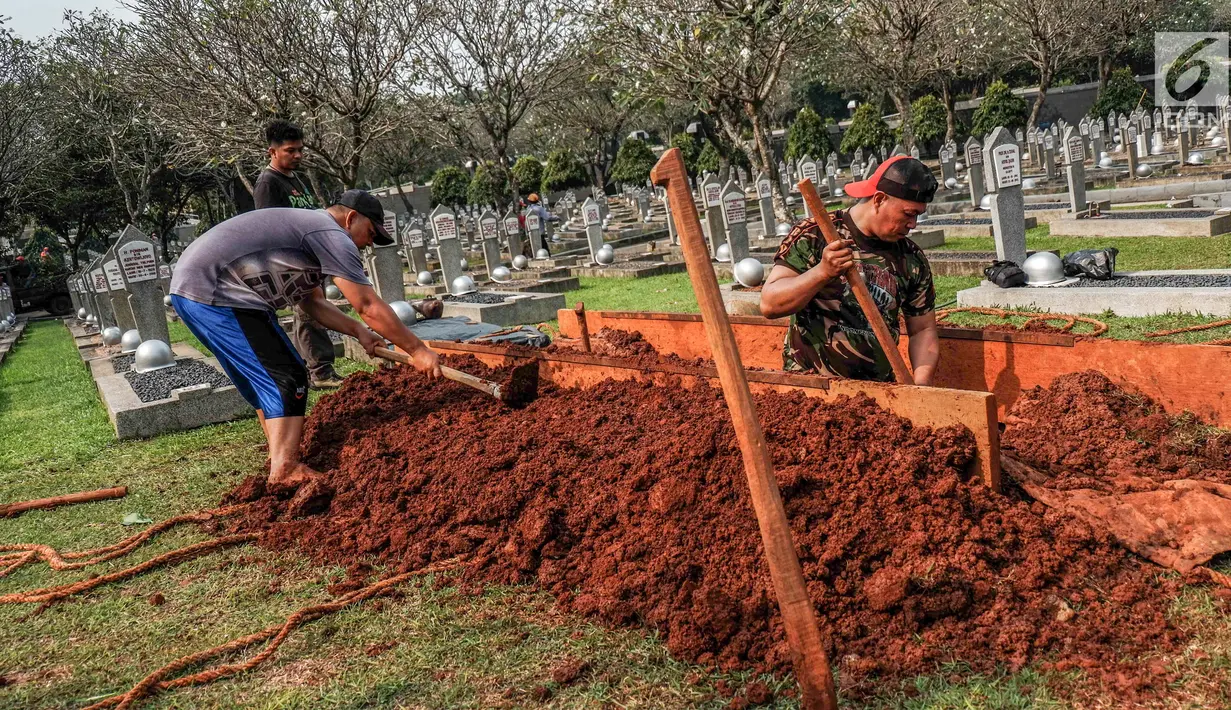 Petugas menggali tanah untuk makam almarhumah Ani Yudhoyono, istri Presiden Ke-6 RI yang berada di Blok M 129 Taman Makam Pahlawan (TMP) Kalibata, Jakarta, Sabtu, (01/6/2019). Lokasi makam berdampingan dengan makam istri Presiden B.J Habibie, Ainun Habibie. (Liputan6.com/Faizal Fanani)