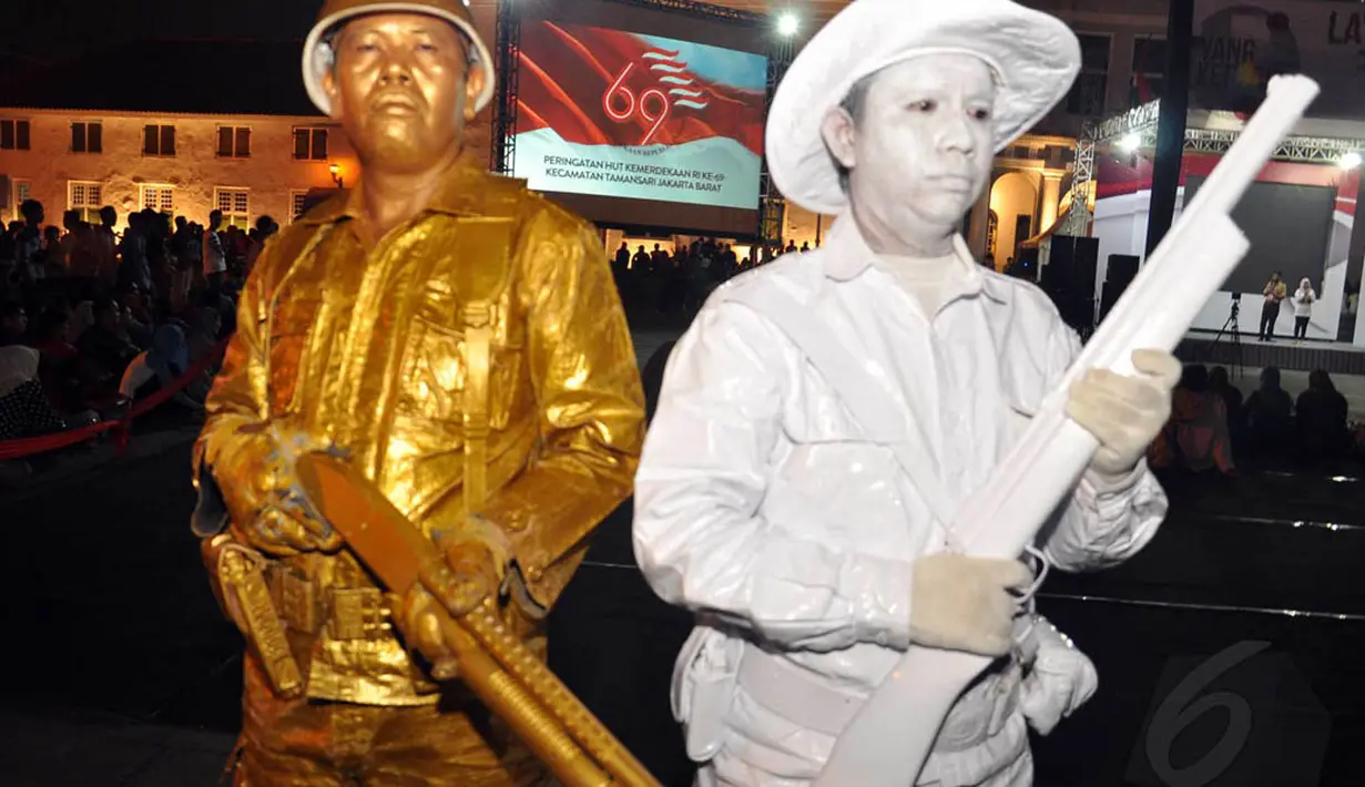 Patung hidup yang dicat seluruh tubuhnya ini dilengkapi dengan aksesories senapan laras panjang, Jakarta, Sabtu (16/8/14). (Liputan6.com/Miftahul Hayat)