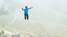 Raphael Bacot dari Swiss berjalan diatas tali saat acara Highline Extreme di puncak Moleson, Swiss (15/9). Mereka berjalan diatas tali dengan panjang 45 meter sampai 304 meter. (AFP Photo/Michael Buholzer)