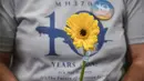 Seorang kerabat memegang bunga dalam sebuah acara yang diadakan oleh para kerabat penumpang untuk memperingati 10 tahun hilang pesawat Malaysia Airlines MH370, di Subang Jaya, pada tanggal 3 Maret 2024. (Arif Kartono/AFP)