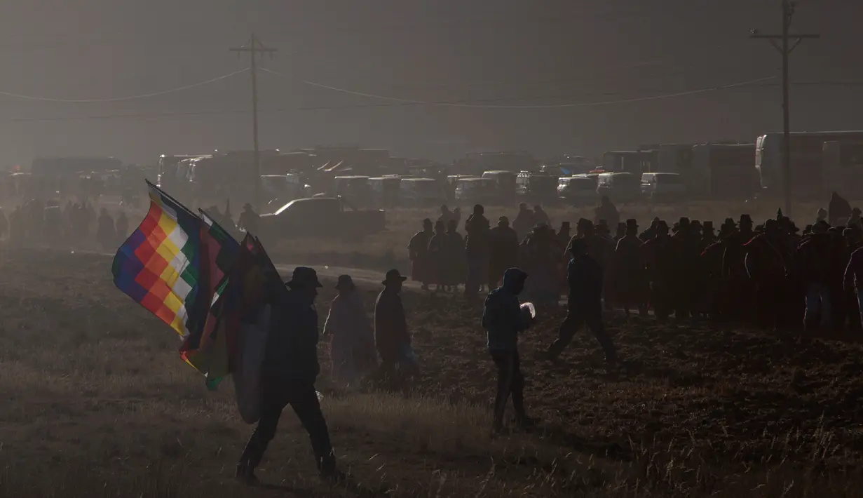 Seorang pribumi suku Aymara membawa bendera untuk mengikuti pawai ulang tahun tentara Bolivia ke-192 di Kjasina, Bolivia (7/8). Upacara ini digelar ditengah gurun karena ingin melibatkan penduduk pribumi asli Bolivia. (AP Photo/Juan Karita)