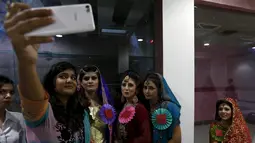 Sejumlah model berselfie di sela kegiatan lomba rias pengantin lokal di Karachi, Pakistan, 22 Maret 2016. Sejumlah wanita mengikuti lomba yang diadakan di sebuah pusat pembelajaan. (REUTERS / Akhtar Soomro)