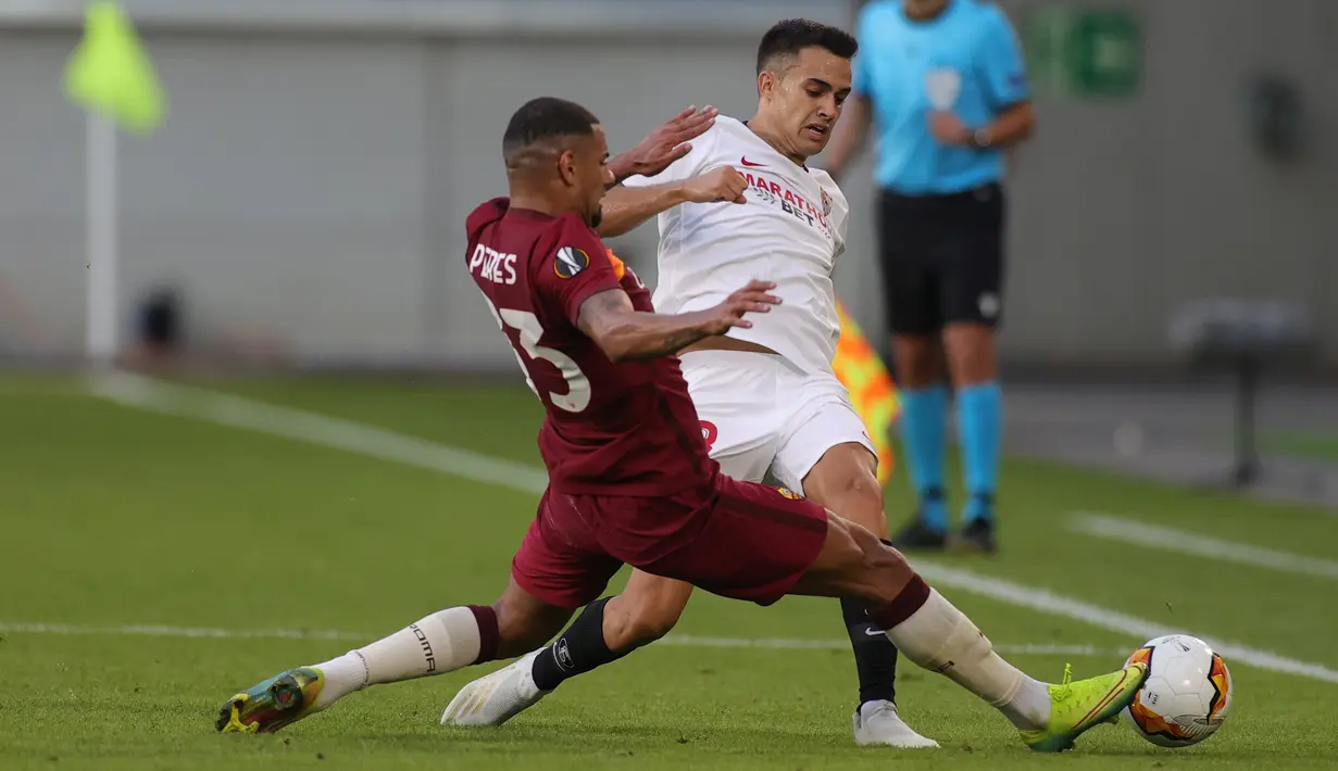Bek Sevilla, Sergio Reguilon, berebut bola dengan bek AS Roma, Bruno Peres, dalam laga babak 16 besar Liga Europa 2019/2020 di MSV-Arena, Jerman, Jumat (7/8/2020) dini hari WIB. Sevilla menang 2-0 atas AS Roma. (AFP/Friedemann Vogel/pool)