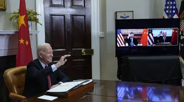 Presiden Joe Biden melambai saat bertemu secara virtual dengan Presiden China Xi Jinping dari Ruang Roosevelt Gedung Putih di Washington, Senin (15/22/2021). Pertemuan dimaksudkan untuk menurunkan ketegangan antara AS dan China selaku dua negara adidaya dunia saat ini. (AP Photo/Susan Walsh)