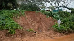 Tanah longsor menutup jalan Raya Kamehameha yang dilapisi dekat Pokole di Kahaluu, Hawaii (9/3/2021). Hujan lebat membuat wilayah tersebut banjir dan dilanda tanah longsor. Warga juga khawatir akan tak berfungsinya bendungan di pulau itu. (Craig T. Kojima/Honolulu Star-Advertiser via AP)