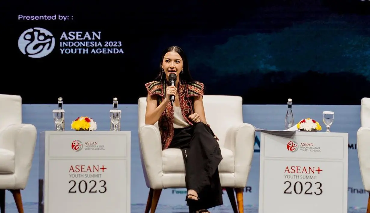 Ia padukan outer batik dengan tanktop satin putih dan celana panjang hitam [@ralineshah]