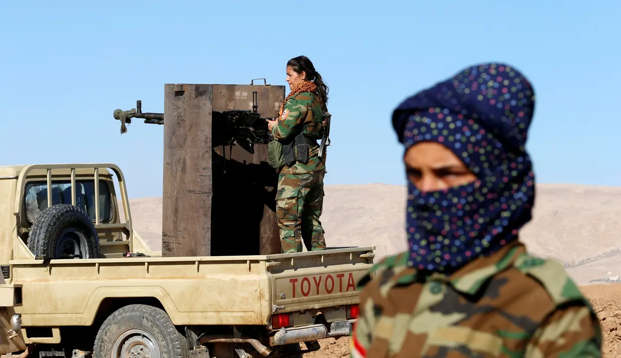Pejuang wanita Iran-Kurdi bersiaga saat pertempuran melawan kelompok radikal ISIS di Bashiqa, dekat Mosul, Irak, Kamis (3/11). Mereka dibagi menjadi beberapa kelompok, yang punya keahlian menguasai berbagai jenis senjata. (Reuters/Ahmed Jadallah)