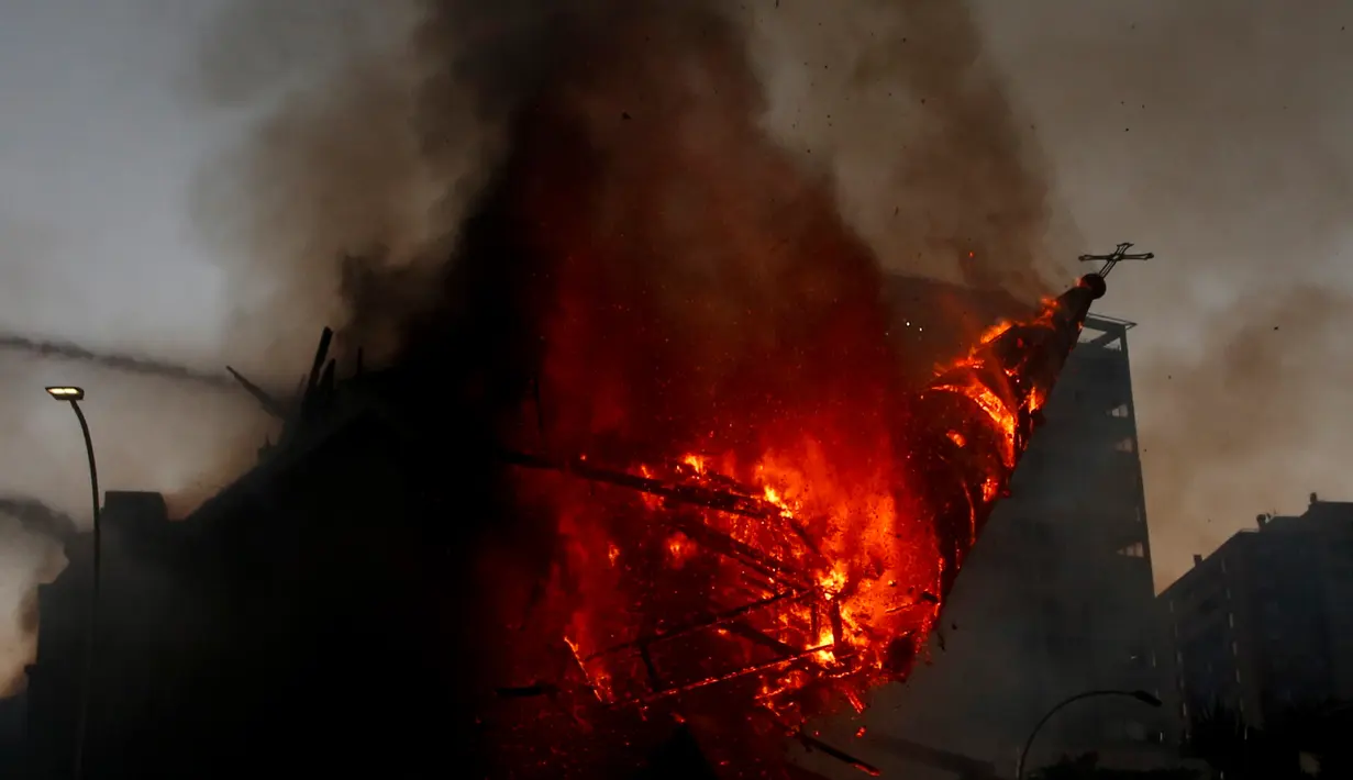 Kubah gereja Asuncion runtuh setelah diserang dan dibakar saat puluhan ribu orang berunjuk rasa di Kota Santiago, Chile, Minggu (18/10/2020). Demonstrasi itu digelar untuk memperingati satu tahun protes besar menuntut kesetaraan di Chile. (AP Photo/Luis Hidalgo)