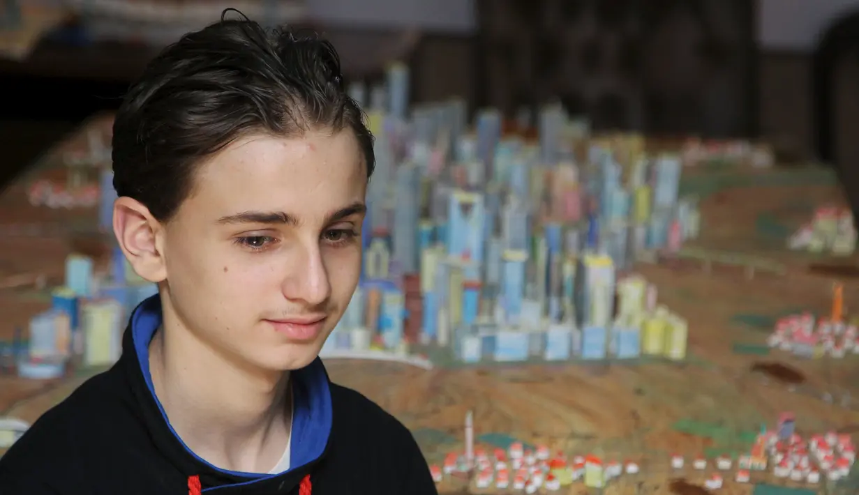 Mohamed Qutaish, 14 tahun berpose depan sebuah kontruksi bangunan kota Aleppo dengan skala kecil buatannya di Suriah, Senin (31/8/2015). Qutaish ingin kota Aleppo menjadi kota yang modern di masa depan.  (REUTERS/Ismail Abdalrhman)