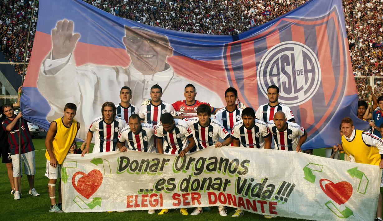 Klub San Lorenzo berfoto bersama dengan latar belakang Banner bergambar Paus Fransiskus sebelum pertandingan melawan Newell Old Boys di Buenos Aires pada 31 Maret 2013. (AFP/NA/Damian Dopacio)