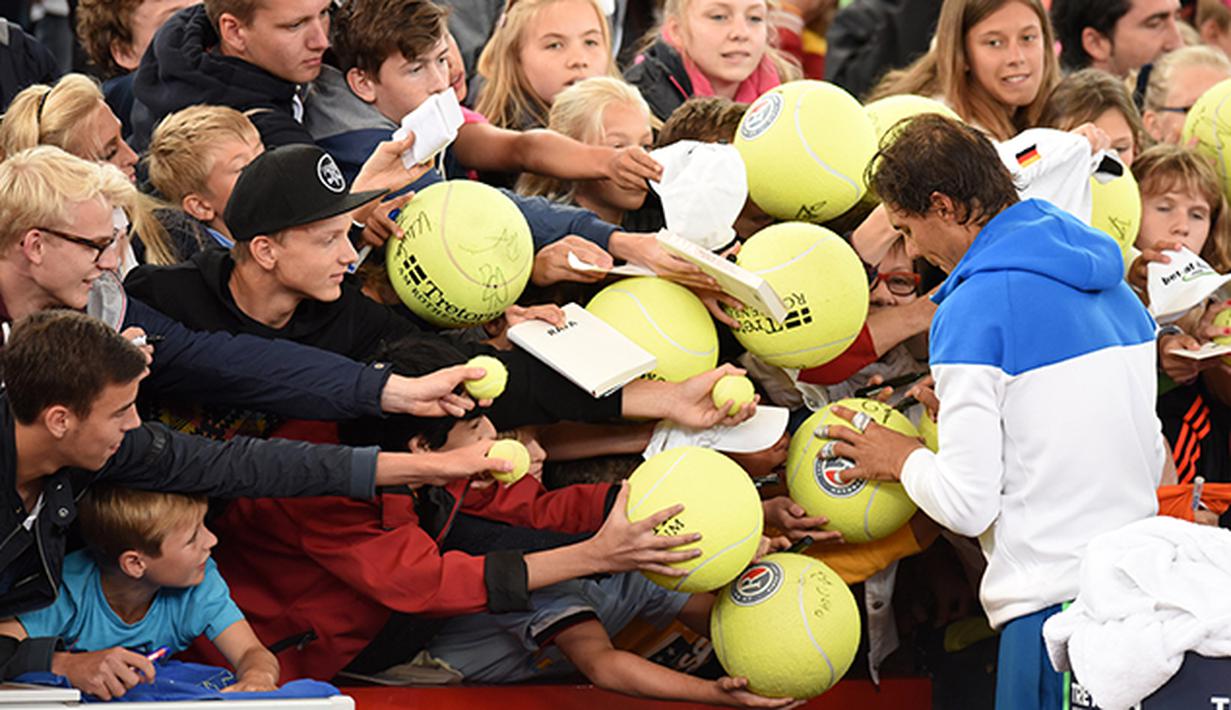 Petenis Spanyol Rafael Nadal memberikan tanda tangan kepada para penggemar jelang bertanding melawan rekan senegaranya Fernando Verdasco pada Turnamen Tenis ATP di Hamburg, Jerman, Selasa (28/7/2015). (EPA/Daniel Bockwoldt)