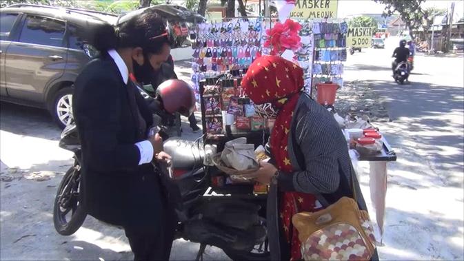 Sufyan Miftahul Arifin Nur memilih berjualan nasi bungkus khas Bali, nasi jinggo saat toko cendera mata tempatnya bekerja di Denpasar, Bali tutup. Dia pun rela berjas dan berdasi rapi guna menarik perhatian pembeli. (Foto: Liputan6.com)