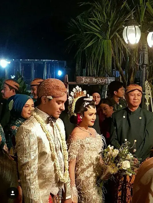 Pernikahan Mytha dan Barry digelar dengan mengusung tema adat Jawa. Mytha yang memakai sanggul serta payesnya begitu anggun dan cantik. Begitu juga dengan Barry yang tampan memakai blangkon dan baju adat Jawanya. (Instagram/nicolette.florist)