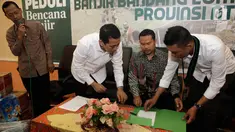 Presidium Majelis Nasional KAHMI, Kamrussamad, Ketua MD Lombok Timur NTT, Ahmad Roji dan Muhammad Ridal  saat menandatangani serah terima bantuan korban banjir di Lombok Timur, Jakarta, Selasa (21/11). (Liputan6.com/Pool/KAHMI)