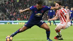 Pemain Manchester United, Antonio Valencia (kiri) mencoba melewati hadangan pemain Stoke City,  Joe Allen pada lanjutan Premier League di Bet365 Stadium, Stoke-on-Trent, (21/1/2017). Setan Merah bermain Imbang 1-1. (AFP/Lindsey Parnaby)