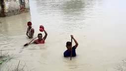 Penduduk desa menerjang banjir di Distrik Muzaffarpur, Negara Bagian Bihar, India timur, pada 26 Juli 2020. Sedikitnya 10 orang tewas dan hampir 1,5 juta orang terkena dampak akibat banjir di 11 distrik di Bihar, papar Departemen Manajemen Bencana Bihar dalam sebuah buletin. (Xinhua/Partha Sarkar)