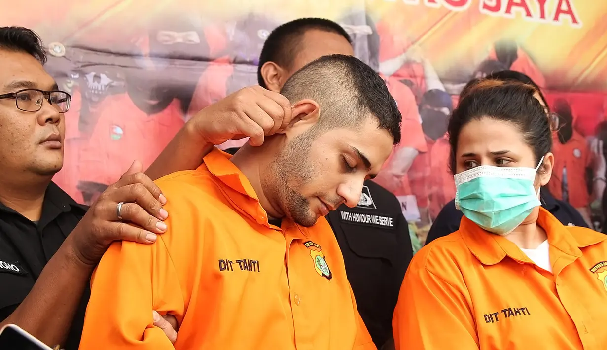 M yang berada disamping kanan Dhawiya terus tertunduk saat polisi merilis perkara kasus narkoba yang menjeratnya. Matanya sering kali terpejam, lantaran sakit. (Bambang E Ros/Bintang.com)