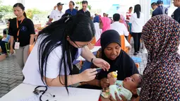 Batita sedang diperiksa kesehatannya di Mataram, NTB, Rabu (15/8). PT Hero Supermarket Tbk memberikan bantuan dan dukungan kepada lingkungan di sekitar toko yang terkena dampak bencana gempa bumi di Lombok Utara. (Liputan6.com/HO/Eko)
