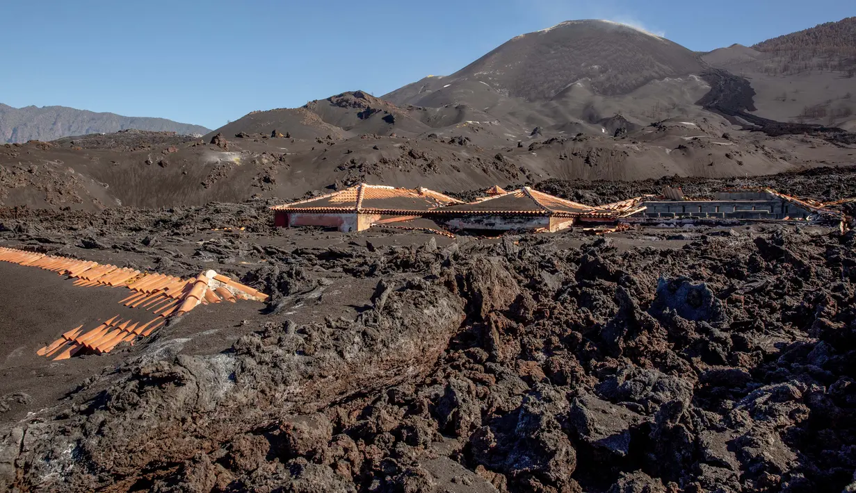 Foto pada 4 Januari 2022 terlihat rumah-rumah yang rusak akibat aliran lahar gunung berapi Cumbre Vieja, di Pulau La Palma, Spanyol. Lava Cumbre Vieja menghancurkan lebih dari 1.300 rumah dan 1.250 hektar lahan, banyak di antaranya ditanami pisang, alpukat atau tanaman merambat. (DESIREE MARTIN/AFP)