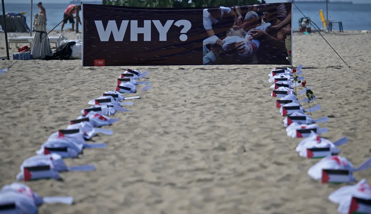 Kain kafan bertuliskan nama-nama anak-anak Palestina yang terbunuh di Gaza berbaris di pantai Copacabana sebagai bentuk solidaritas terhadap para korban perang antara Israel dan Hamas. (Carl DE SOUZA / AFP)