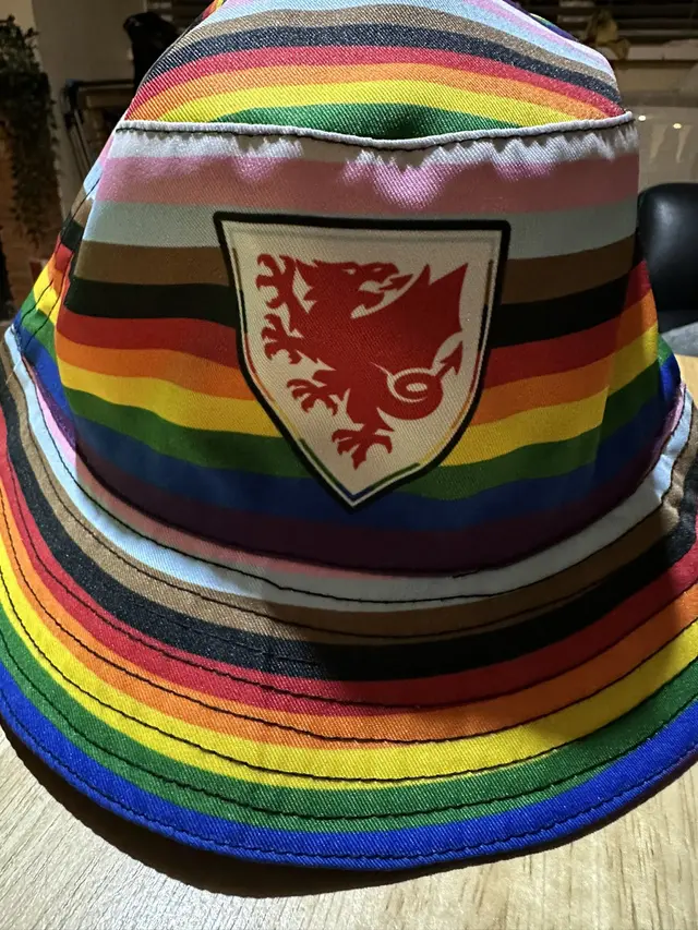 Our rainbow bucket hat. We are so proud of them, BUT news on the ground tonight is our welsh female supporters wearing them in #Qatar are having them taken off them, Not the men, just Women.