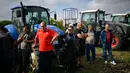 Para petani berdiri di depan traktor mereka dalam sebuah protes menentang pencabutan larangan impor biji-bijian yang berasal dari Ukraina, di Dolni Bogrov, dekat Sofia, pada tanggal 19 September 2023. (Nikolay DOYCHINOV/AFP)