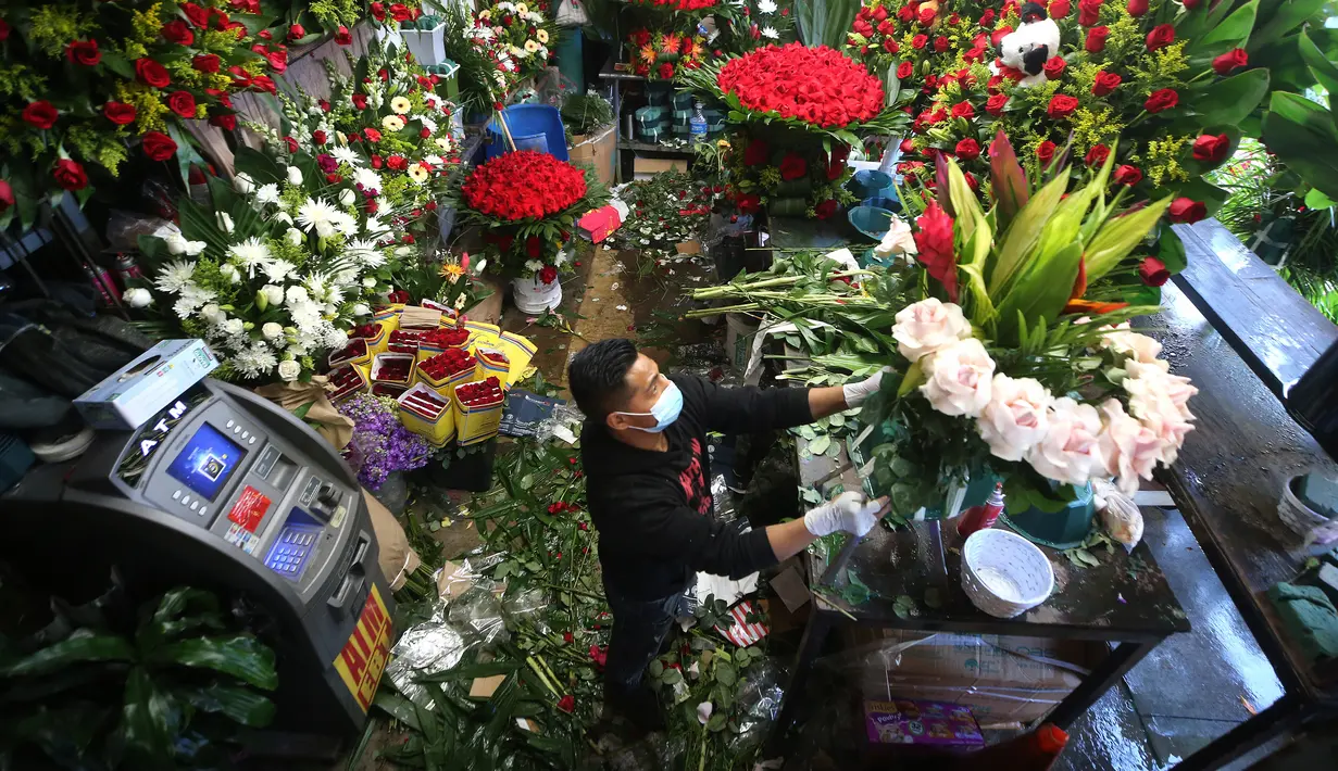 Pedagang bunga merangkai bunga Valentine di distrik bunga sebelum Hari Valentine di tengah pandemi COVID-19 di Los Angeles, California (12/2/2021). Toko bunga di daerah tersebut sibuk tahun ini dengan pemesanan bunga Hari Valentine dan karangan bunga pemakaman COVID-19. (Mario Tama/Getty Images/AFP)