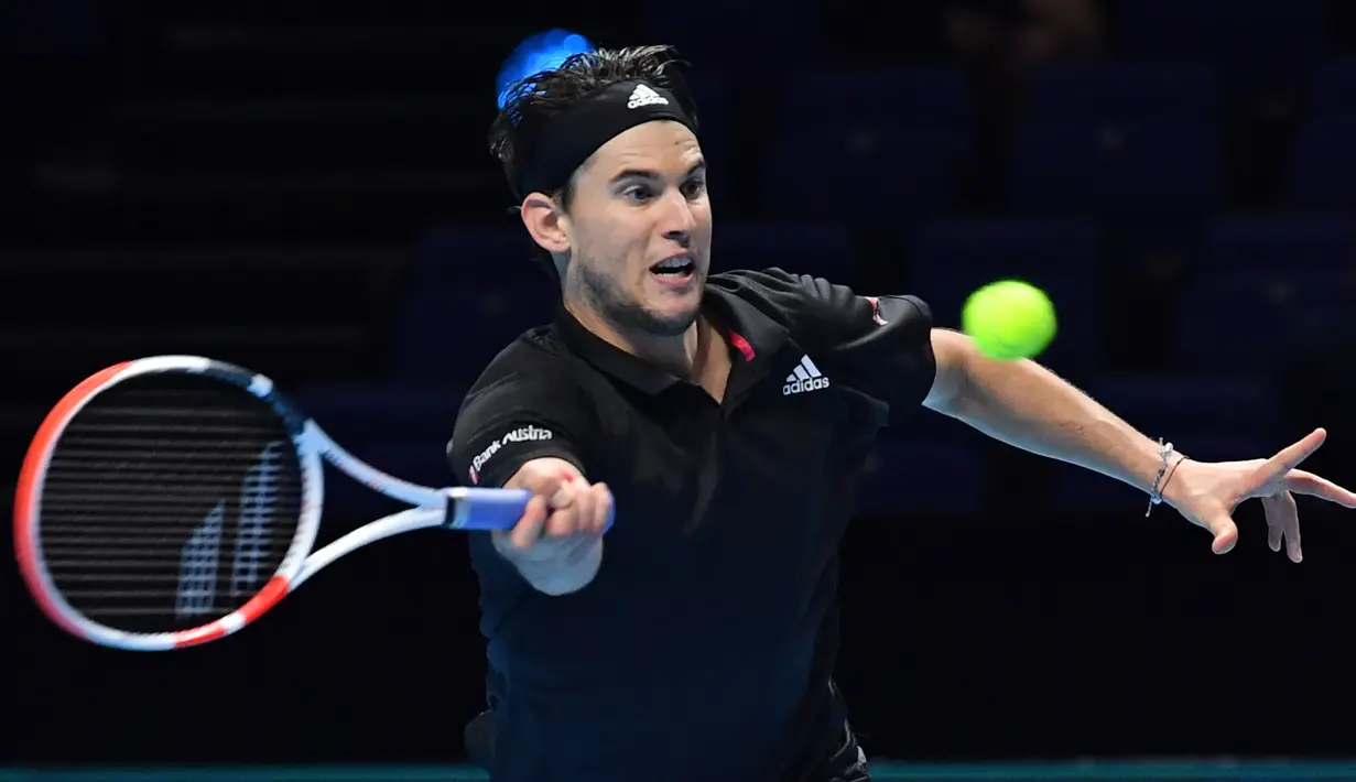 Petenis Austria, Dominic Thiem, mengembalikan bola ke arah lawannya, petenis Rusia, Daniil Medvedev dalam partai final tunggal putra Turnamen Tenis ATP Finals 2020 di O2 Arena, London, Inggris, Minggu (22/11/2020). Dominic Thiem kalah dengan skor 6-4, 6-7 (2), 4-6. (AFP/Glyn Kirk)