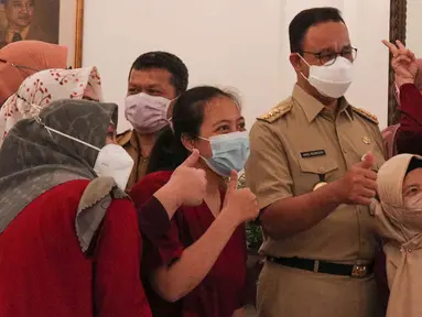 Gubernur DKI Jakarta Anies Baswedan berswafoto dengan pegawai Pemprov DKI saat halal bihalal di Balai Kota DKI, Jakarta, Senin (9/5/2022). Anies Baswedan menggelar halal bihalal bersama para ASN Pemprov DKI Jakarta seusai libur Lebaran 2022. (Liputan6.com/Herman Zakharia)