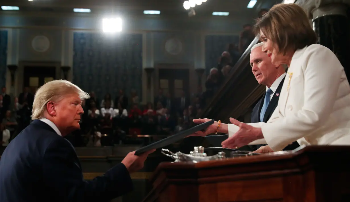 Presiden Amerika Serikat Donald Trump (kiri) menyerahkan naskah pidato kenegaraannya kepada Ketua DPR Nancy Pelosi dalam Kongres di Capitol Hill, Washington, Selasa (4/2/2020). Trump menyampaikan pidatonya sehari jelang keputusan persidangan pemakzulannya di level Senat AS. (Leah Millis/Pool via AP)