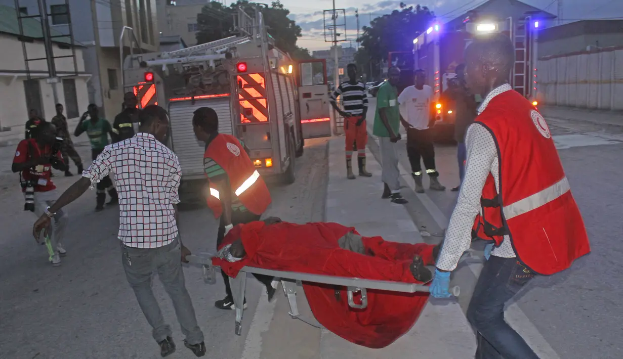 Petugas mengevakuasi korban yang terluka akibat serangan bom mobil di Mogadishu, Somalia (8/5). Lokasi serangan berada di sebuah restoran dan kedai kopi terkenal di Mogadishu, Italian Cafe. (AP Photo/Farah Abdi Warsameh)