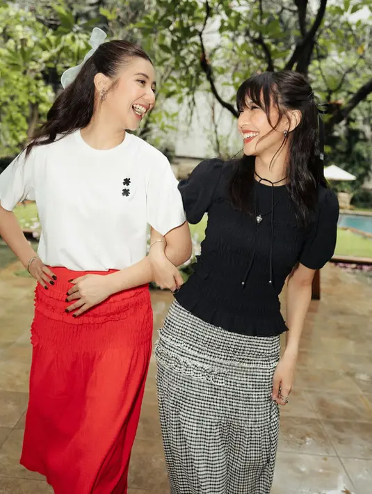 Sheila Dara memilih tampilan monokrom dengan T-shirt kerut hitam berlengan bervolume yang dipadukan bersama rok gingham hitam-putih beraksen kerut. Look tersebut memberi kesan clean, chic, sekaligus effortless. Detail pita hitam kecil di rambut Sheila membuat aura soft girl-nya semakin terasa. [@sheiladara].