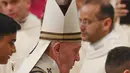 Paus Fransiskus membawa  patung bayi Yesus setelah memimpin misa Malam Natal di Basilika Santo Petrus, Vatikan, Selasa (24/12/2019). Paus Fransiskus memberikan khotbahnya seputar makna spiritual dan pribadi mengenai malam saat Yesus dilahirkan di Betlehem. (AP Photo/Alessandra Tarantino)