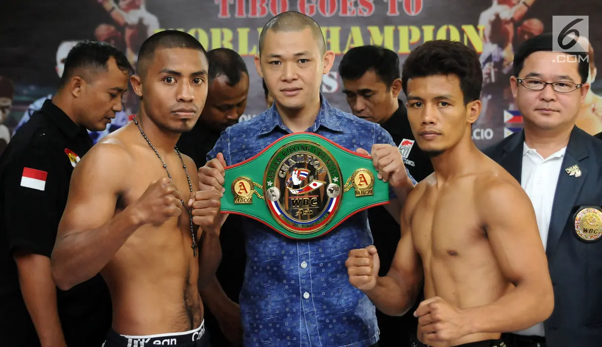 Petinju Indonesia Defry Palulu (kiri) bersama Nathan Bolcio (Filipina) usai melakukan timbang  badan di GOR Cendrawasih, Jakarta, Jumat (19/5). Keduannya akan memperebutkan gelar WBC Asia.  (Liputan6.com/Helmi Fithriansyah)
