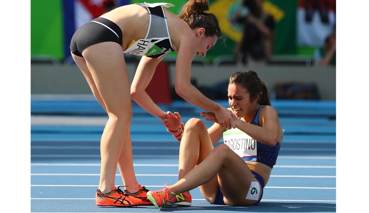 Pelari Nikki Hamblin dari Selandia Baru membantu pelari AS, Abbey D'Agostino, saat mengalami nyeri kaki setelah terjatuh pada lari 5000m putri Olimpiade Rio 2016 di Olympic Stadium, Rio de Janeiro, Brasil, (16/8/2016). (Reuters/Kai Pfaffenbach)