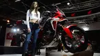 Model berpose di samping motor Honda Africa Win saat Indian Auto Expo 2018 di Greater Noida, New Delhi, India, (7/2). (AFP Photo/Sajjad Hussain)