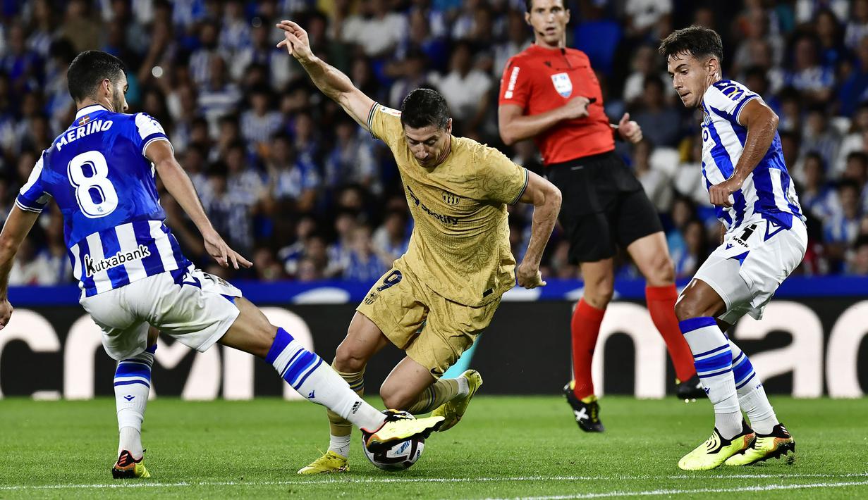 Berawal dari serangan balik Barcelona yang diinisiasi Alex Balde, bola kemudian diumpan ke Lewandowski. Pria 34 tahun itu berhasil melesatkan bola dengan kaki kirinya dari dalam kotak penalti meski dikawal ketat oleh pemain belakang Real Sociedad. (AP/Alvaro Barrientos)