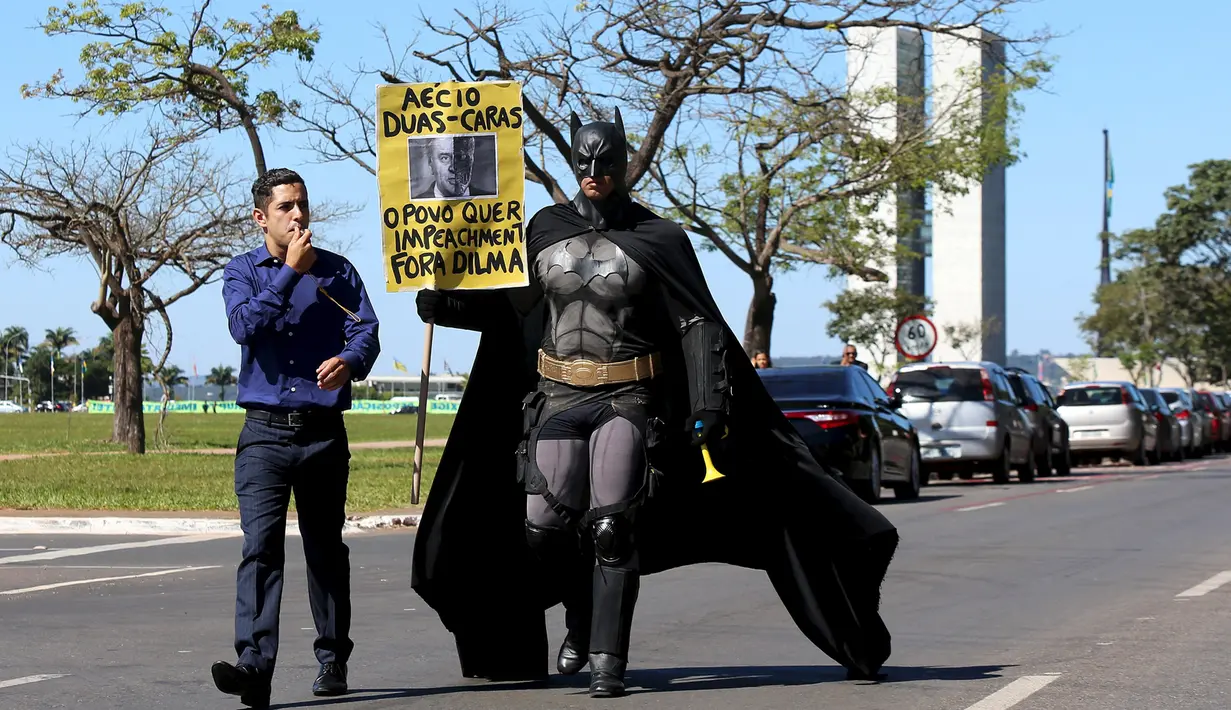 Seorang aktivis mengenakan kostum superhero Batman turun ke jalan memprotes Presiden Brasil Dilma Rousseff di Gedung Kongres Nasional, Brasil (27/5/2015). Aktivis ini menuntut keadilan terkait kebijakan pemotongan anggaran. (REUTERS/Adriano Machado)