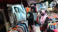 Calon pembeli memilih pakaian bekas di salah satu kios Pasar Senen Blok III, Jakarta, Kamis (11/6/2020). Pasar yang tetap buka saat PSBB dengan pembatasan jam operasional ini akan kembali dibuka secara normal pada 15 Juni 2020 dengan aturan protokol kesehatan COVID-19. (Liputan6.com/Herman Zakharia)