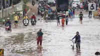 Pengendara dan pejalan kaki melewati perempatan Green Garden, Kedoya, Jakarta, Jumat (3/1/2020). Hingga hari ke-3, banjir masih menggenangi sekitar kawasan perempatan Green Garden, Kedoya akibatnya pengendara harus lebih waspada menghindari mesin kemasukan air. (Liputan6.com/Helmi Fithriansyah)