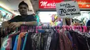 Seorang penjual tampak bergaya di dekat barang dagangannya di Pasar Tanah Abang, Jakarta, Kamis (2/7/2015). Memasuki pertengahan Ramadan pedagang mengaku penjualan baju muslim meningkat dari bulan-bulan sebelumnya. (Liputan6.com/Yoppy Renato)