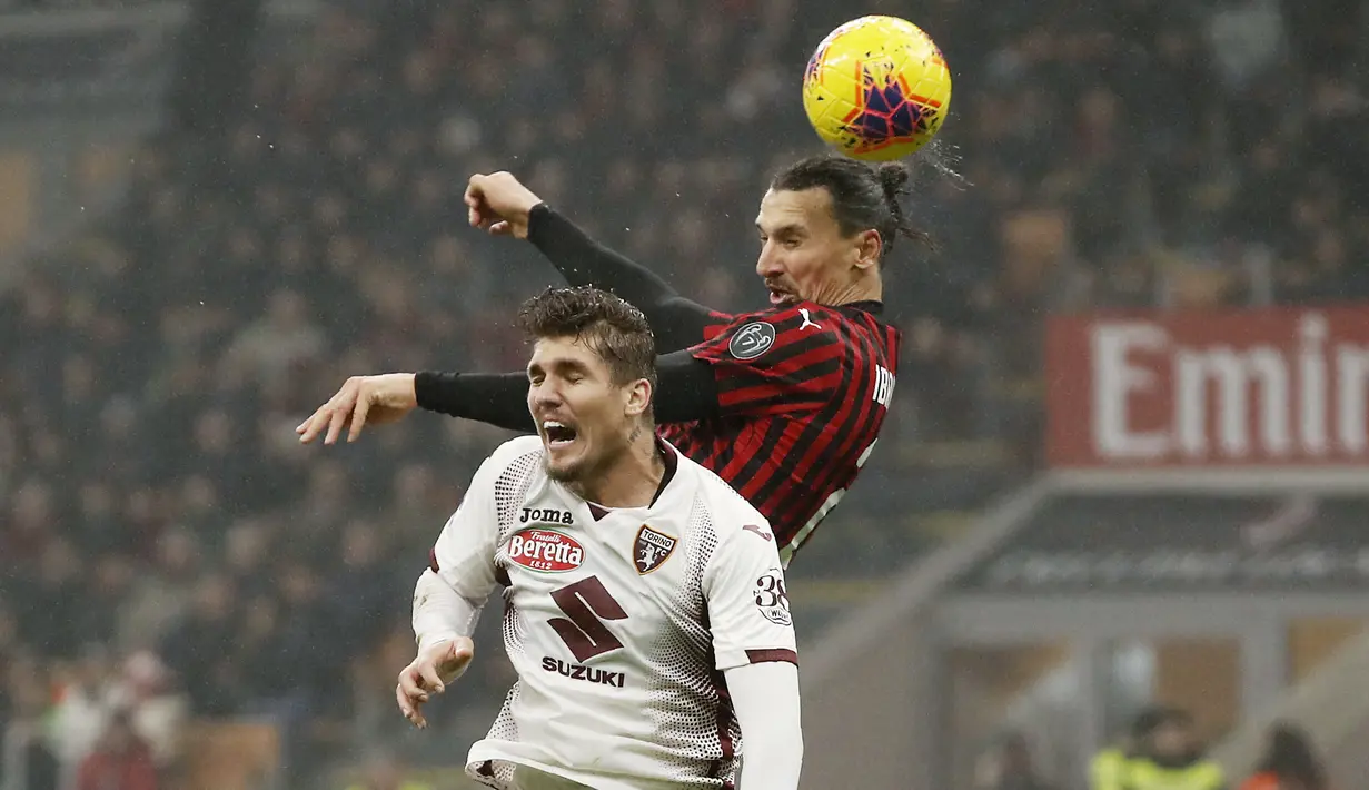 Penyerang AC Milan, Zlatan Ibrahimovic berebut bola udara dengan bek Torino, Lyanco  pada pertandingan lanjutan Liga Serie A Italia di stadion San Siro, di Milan, Italia, (18/2/2020). Milan menang tipis atas Torino 1-0. (AP Photo/Antonio Calanni)