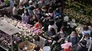 Orang-orang berjalan melalui pasar bunga menjelang Tahun Baru Imlek di daerah Prince Edward Hong Kong (16/1/2022). Tahun Baru Imlek China jatuh pada 1 Februari 2022. (AFP/Bertha Wang)