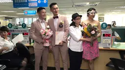 Pasangan sesama jenis Shane Lin dan Marc Yuan serta Cynical Chick dan Li Ying-Chien berpose di kantor pemerintahan Taipei, Taiwan, Jumat (24/5/2019). Diperkirakan ada sekitar 300 pasangan sesama jenis lainnya yang mendaftarkan pernikahan mereka pada hari yang sama. (AP Photo/Johnson Lai)