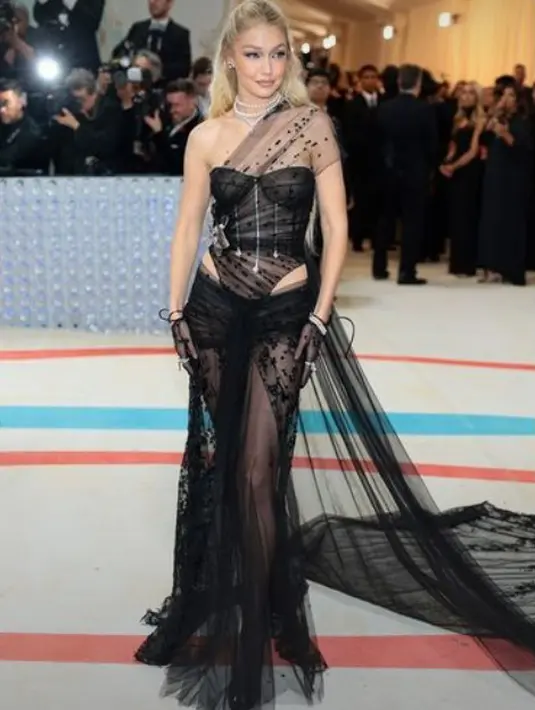Gigi Hadid tampil edgy dengan gaun sheer dari Givenchy. Gaun transparan ini memiliki detail payet hitam dengan potongan cutout di bagian pinggang [@givenchy]