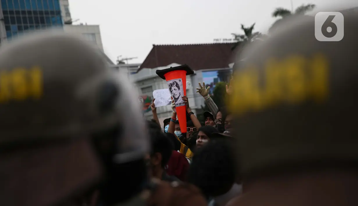 Pengunjuk rasa membawa poster bergambar almarhum Munir saat berdemonstrasi menolak UU Cipta Kerja di kawasan Harmoni, Jakarta, Kamis (8/10/2020). UU Cipta Kerja yang disahkan beberapa waktu lalu memicu demonstasi sejumlah kalangan. (Liputan6.com/Faizal Fanani)