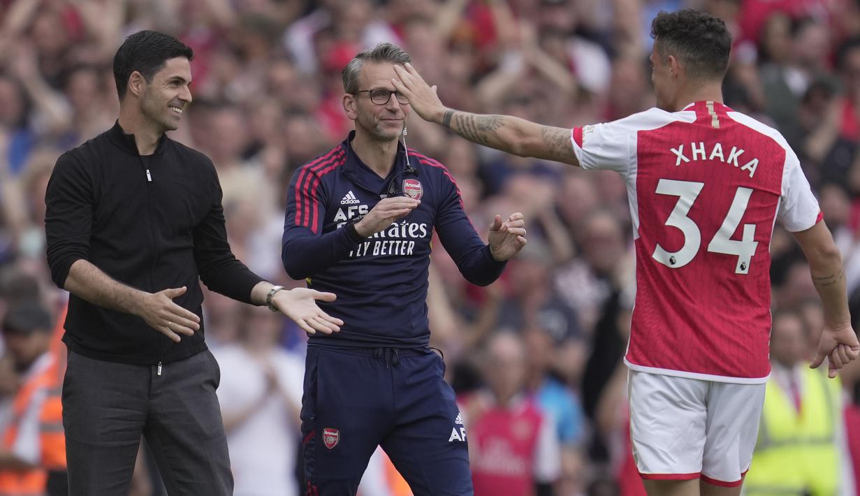 Pemain Arsenal, Granit Xhaka melakukan selebrasi dengan Mikel Arteta setelah mencetak gol ke gawang Wolverhampton Wanderers dalam laga pamungkas English Premier league 2022/2023 yang berlangsung di Emirates Stadium, Minggu (28/5/2023). (AP Photo/Kin Cheung)