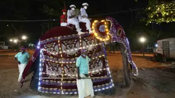 Warga mengenakan pakaian tradisional saat mengendarai gajah yang dihias pada Festival Navam Perahera di Kolombo, Sri Lanka, 15 Februari 2022. Biksu, penari, pemusik, dan lainnya berpartisipasi dalam perayaan di Kuil Gangaramaya yang terkenal. (AP Photo/Eranga Jayawardena)
