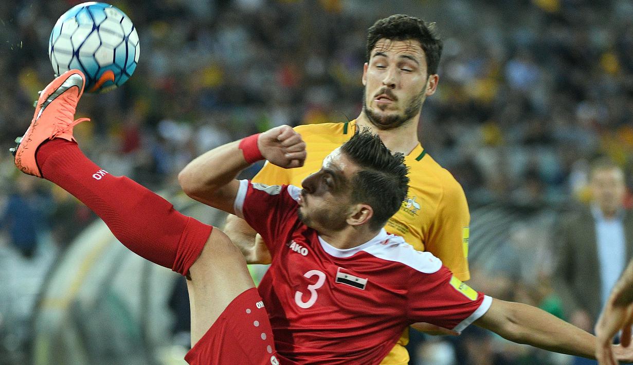 Aksi pemain Suriah, Mouaiad Ajjan saat berebut bola dengan pemain Australia, Mathew Leckie (kanan) pada laga kualifikasi Piala Dunia 2018 di  Sydney (10/10/2017). Australia menang 2-1 pada leg kedua tersebut. (AFP/Saeed Khan)